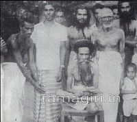 Gurupadar with disciples in His Ashram. Shekharan is standing behind Him. Shekharan later became Jagadguru Swami Sathyananda Saraswathi, His successor.